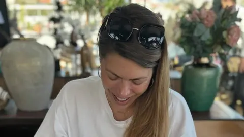 Blanka Vlašić s osmijehom gleda prema dolje, sunčane naočale na kosi.