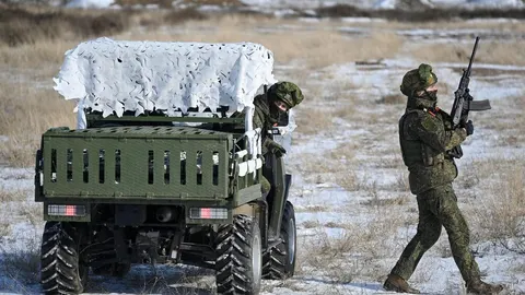 Vojnici u maskirnim uniformama s terenskim vozilom na zasnježenom polju.