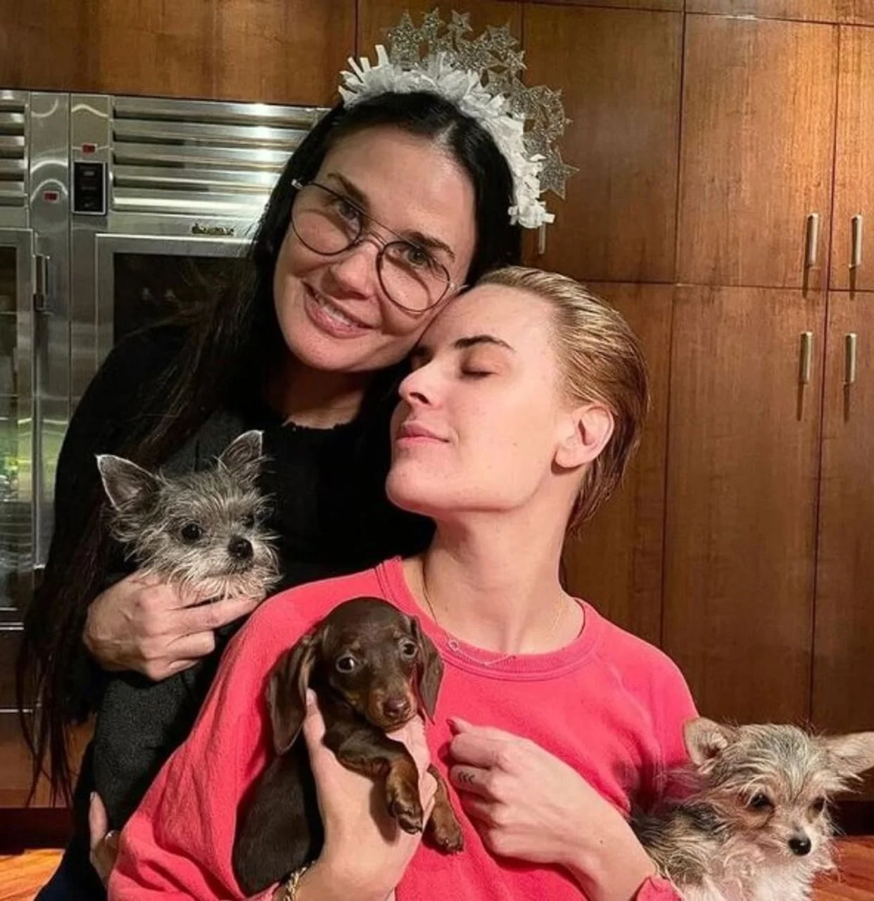 Demi Moore i kći u kuhinji s drvenim ormarićima drže male pse