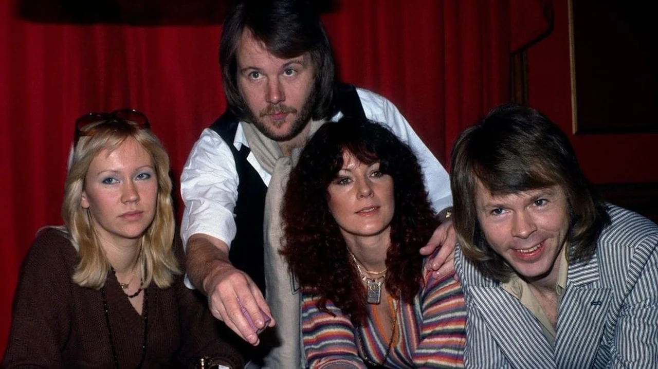 Članovi grupe ABBA sjede ispred crvene zavjese
