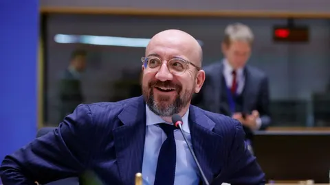 Charles Michel s naočalama i tamnim odijelom govori za mikrofonom u dvorani.