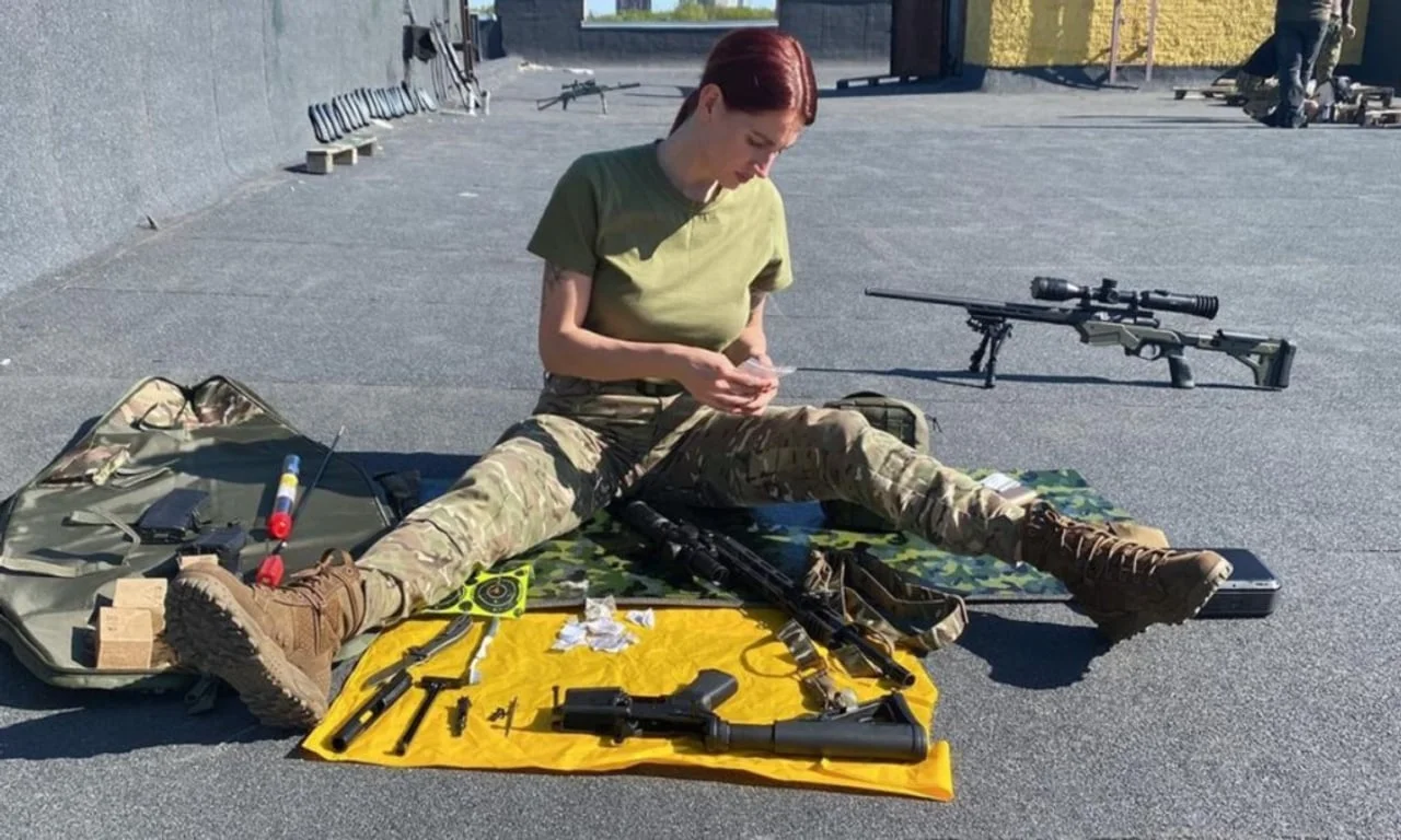 Vojnikinja čisti i priprema snajpersku opremu na otvorenom