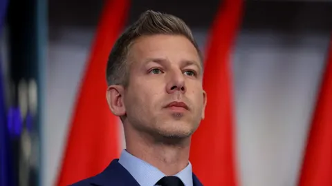 Peter Magyar s ozbiljnim izrazom lica ispred crvenih zastava