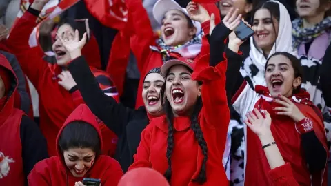 Iranske navijačice u crvenoj odjeći radosno navijaju na stadionu