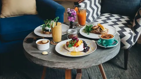 Raznolik doručak s kavom, voćem i tostovima na stolu u kafiću