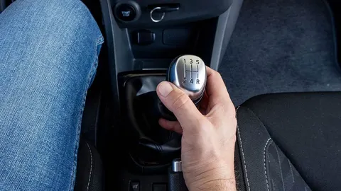 Ruka vozača na ručici mjenjača u automobilu tijekom vožnje.