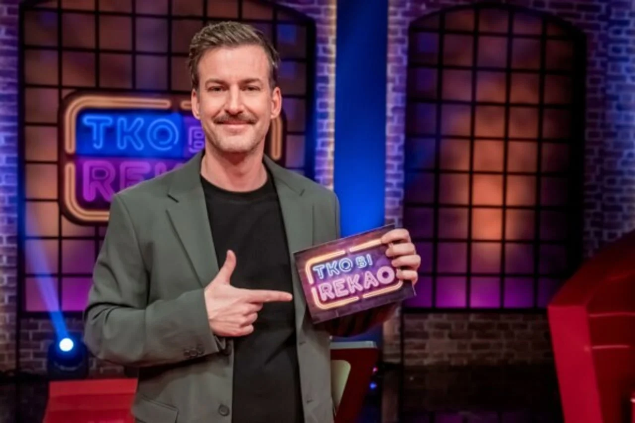 Matija Kačan u studiju emisije Tko bi rekao drži pločicu s logotipom.