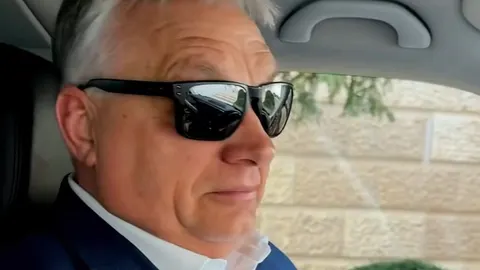 Viktor Orbán s crnim sunčanim naočalama sjedi u automobilu.