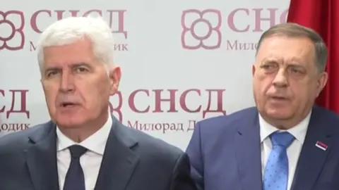Dragan Čović i Milorad Dodik stoje jedan pored drugoga ispred oznaka SNSD-a.