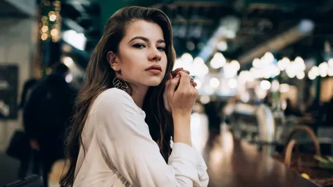 Mlada žena ozbiljnog izraza lica sjedi u restoranu