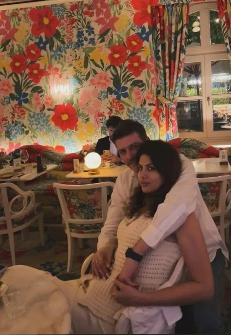 Amar i Alma Bukvić u zagrljaju u restoranu sa šarenim tapetama