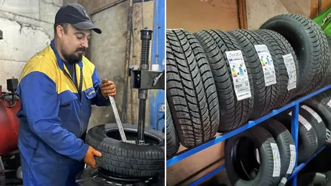 Automehaničar montira crnu gumu na felgu u radionici i nove gume na polici