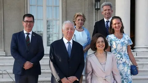 Skupina ljudi u svečanoj odjeći ispred bijele palače