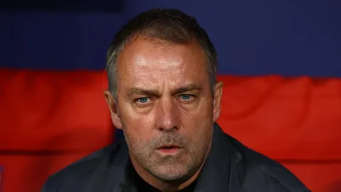 Hansi Flick u krupnom planu s ozbiljnim izrazom lica na stadionu.