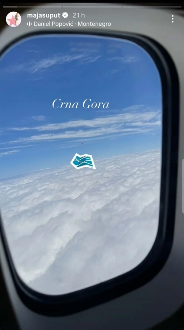 Pogled kroz prozor aviona na oblake s natpisom Crna Gora