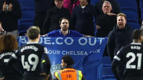 Razočarani navijači Chelseaja na tribinama drže plavi prosvjedni transparent.