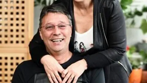 Nasmijani Hari Rončević s naočalama dok ga supruga Nelsi grli oko ramena.