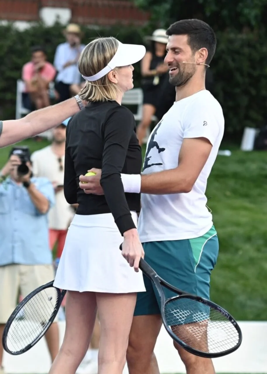 Profil glumice Charlize Theron u sportskoj odjeći s teniskim reketom.