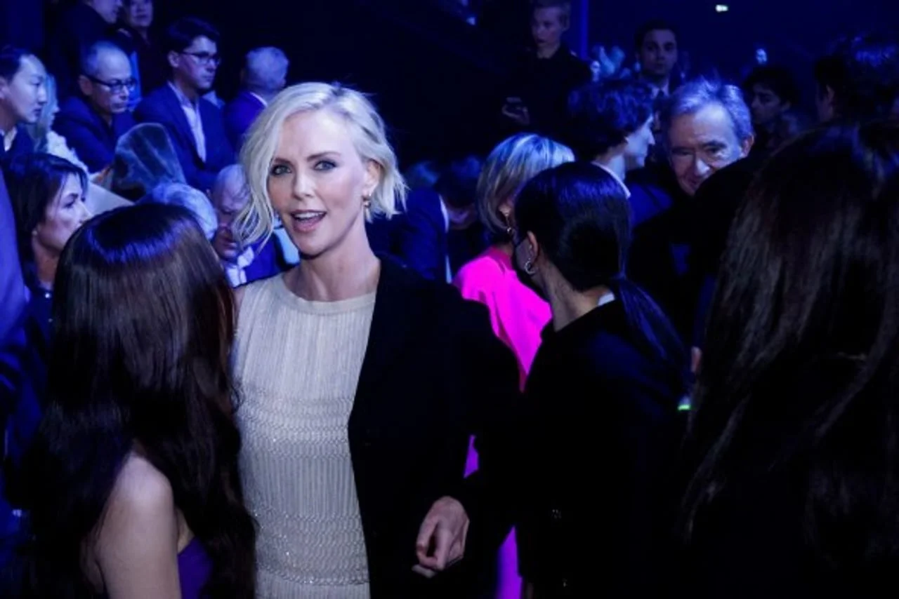 Charlize Theron nasmijana u gužvi tijekom večernjeg događaja.