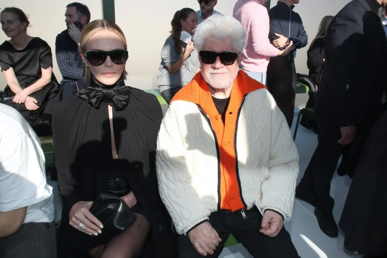 Charlize Theron i Pedro Almodóvar sjede zajedno u prvom redu revije.