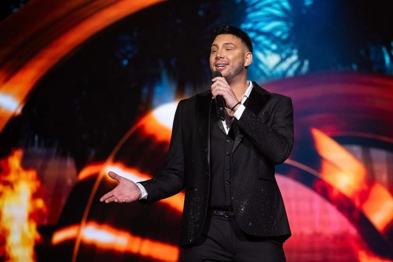 Alen Bičević nastupa s mikrofonom u ruci na pozornici