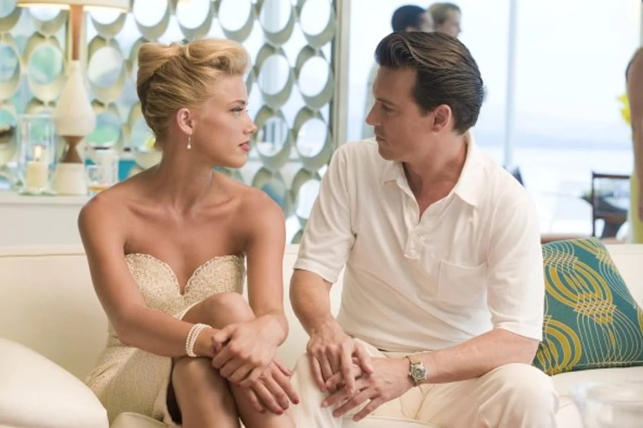 Amber Heard i Johnny Depp sjede na kauču u elegantnoj odjeći