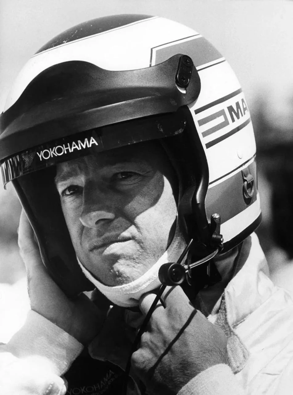 Mark Tačer s trkaćom kacigom na glavi gleda u stranu