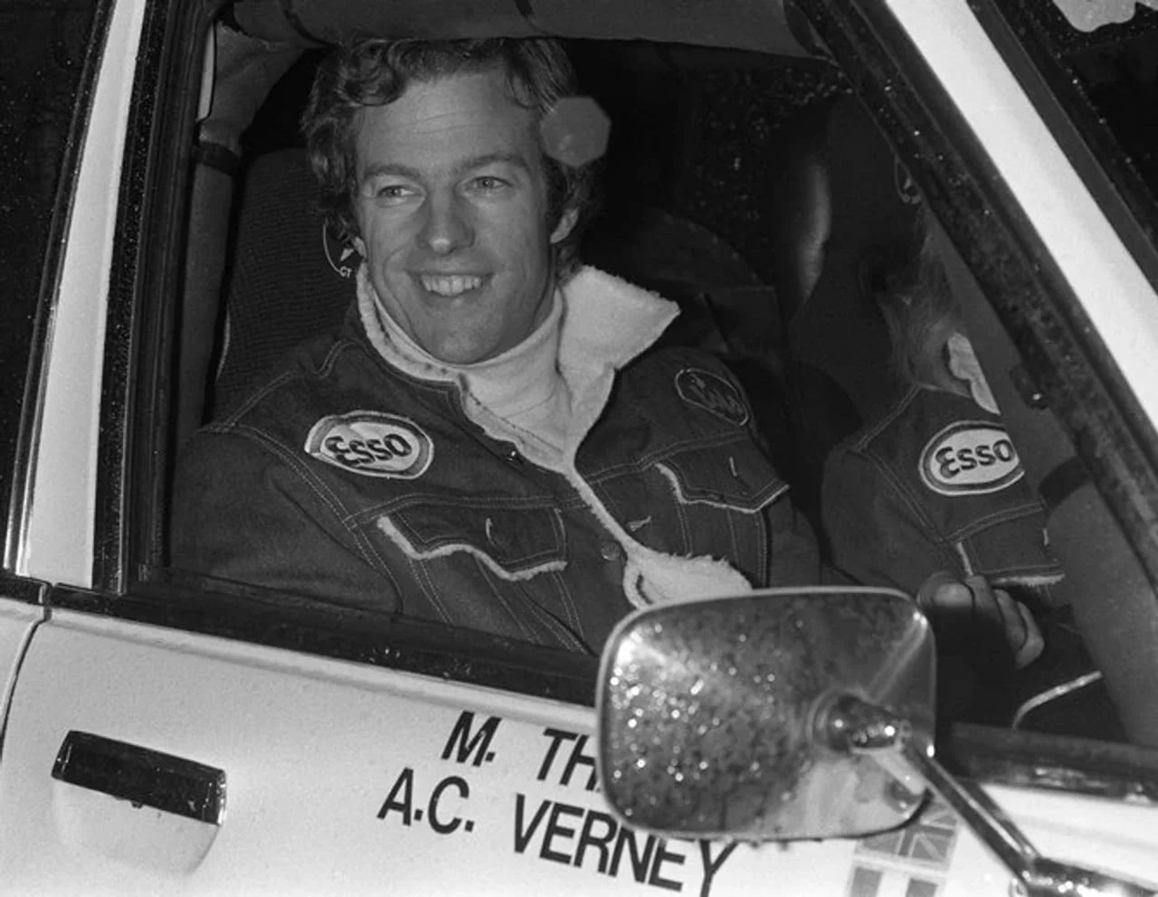 Nasmijani Mark Tačer u reli automobilu nosi jaknu s logotipom