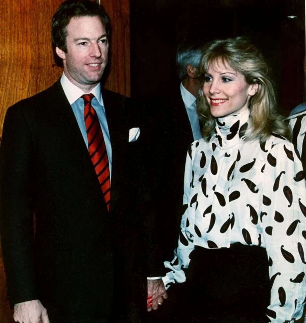 Mark Tačer u odijelu drži ženu za ruku na društvenom događaju