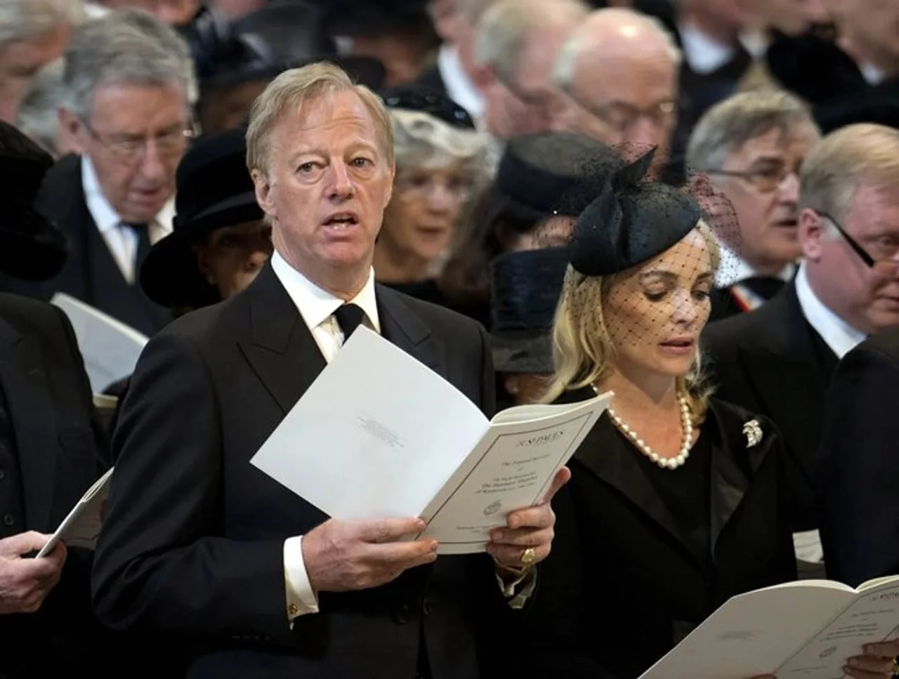 Mark Tačer i žena u crnini drže moliitvenike u crkvi