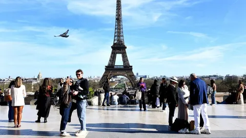 Gomila turista na trgu Trocadéro ispred Eiffelovog tornja u Parizu.
