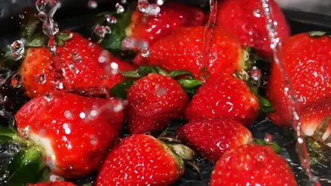 Svježe crvene jagode pod mlazom čiste vode