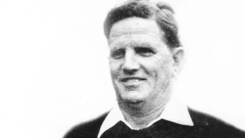 Crno-bijeli portret Lea Lemešića u sportskoj odjeći s bijelim ovratnikom.