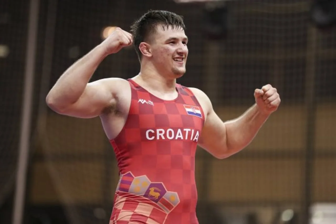 Mladi hrvač u crvenom dresu Hrvatske slavi pobjedu.