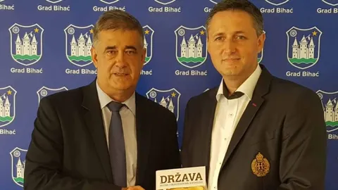 Šuhret Fazlić i Denis Bećirović poziraju ispred znaka Grada Bihaća.