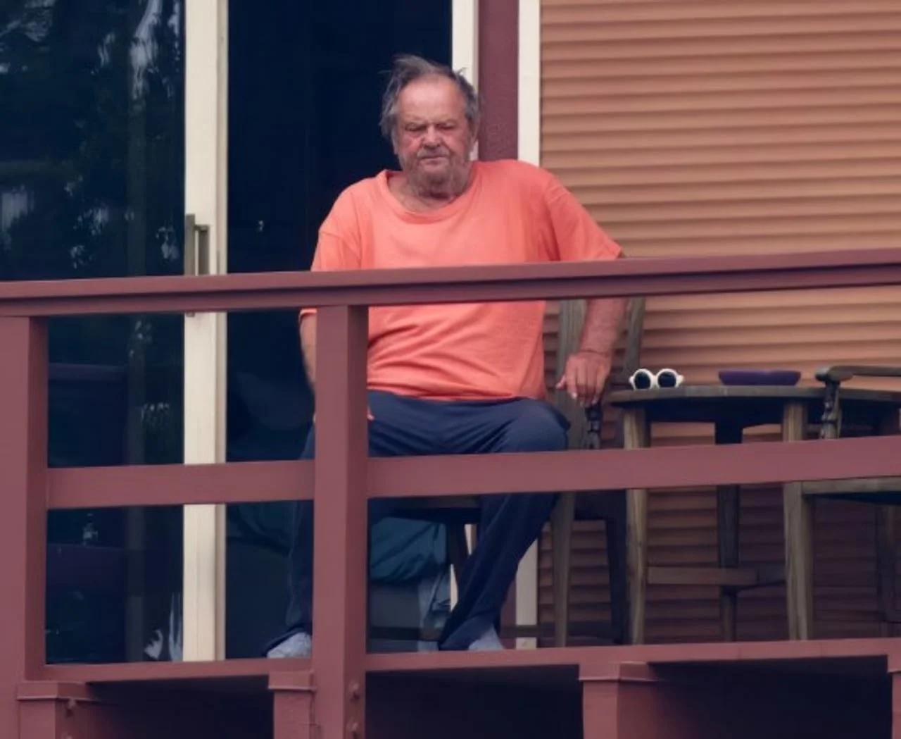 Jack Nicholson sjedi na svom balkonu u majici narančaste boje.