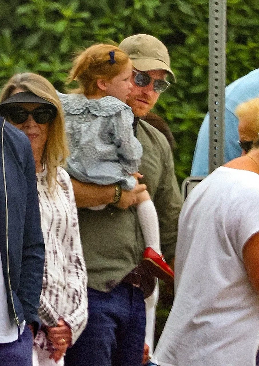 Princ Harry s kapom i sunčanim naočalama nosi kćer Lilibet.