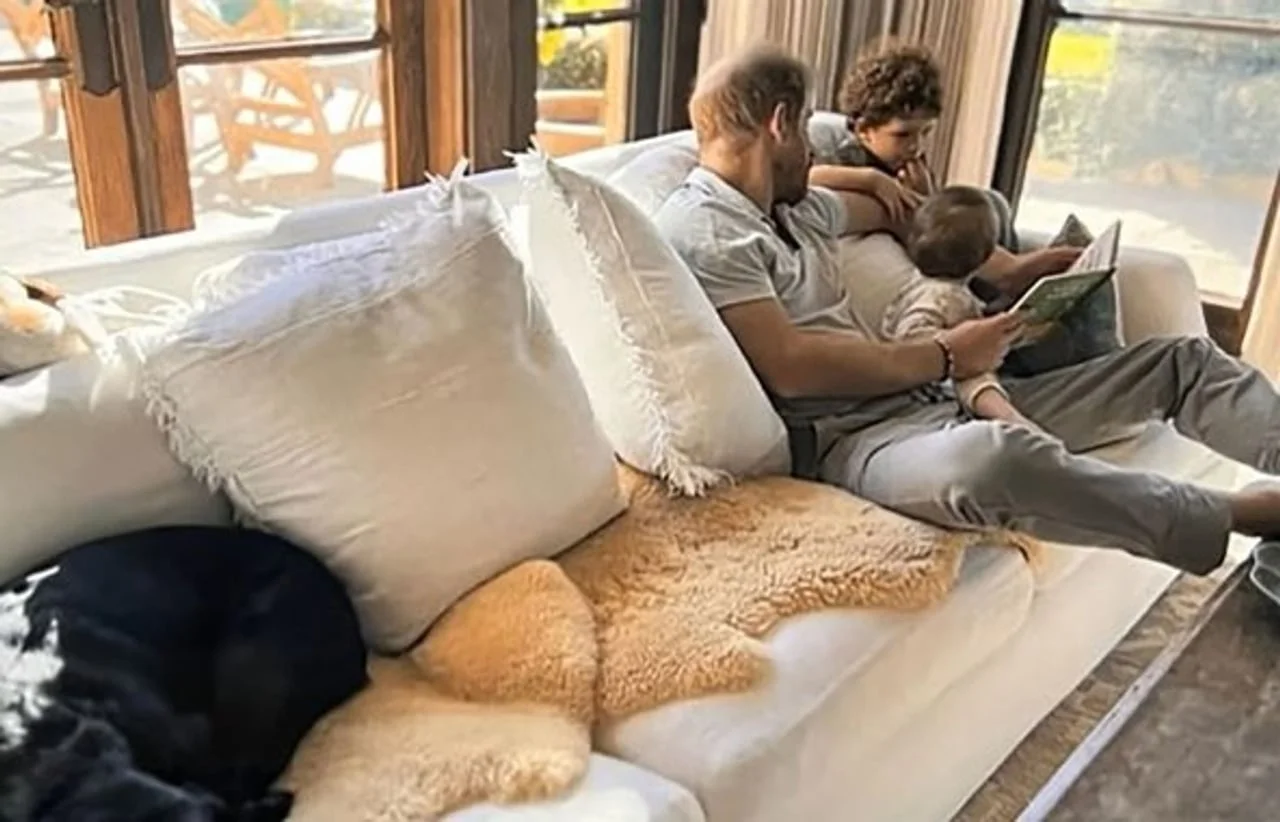 Interijer s bijelim kaučem i princem Harryjem koji čita djeci.