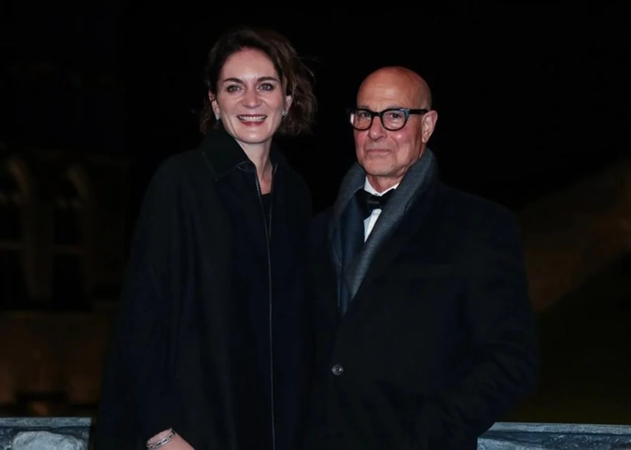 Stanley Tucci i Felicity Blunt poziraju nasmiješeni u tamnoj odjeći.
