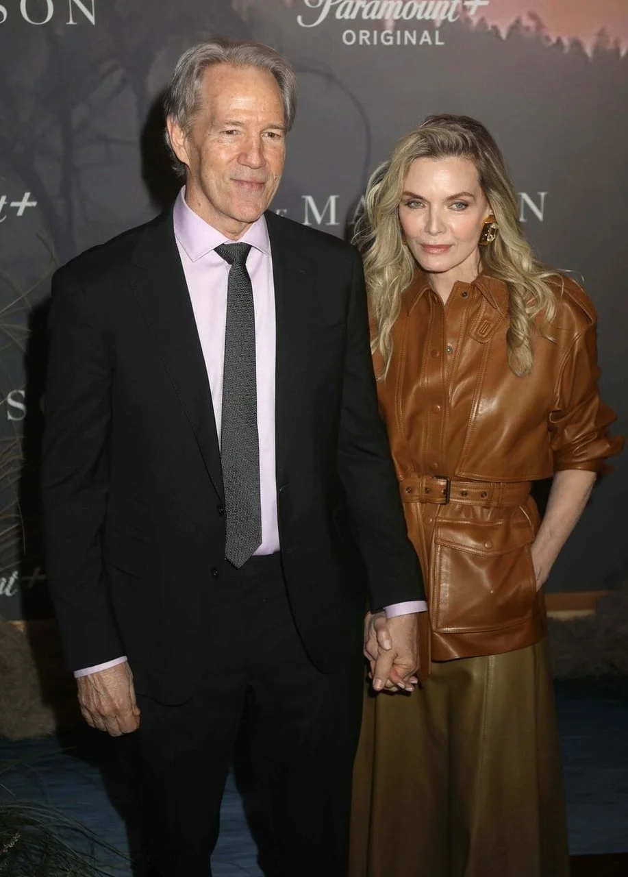 Michelle Pfeiffer i David E. Kelley poziraju držeći se za ruke na crvenom tepihu.