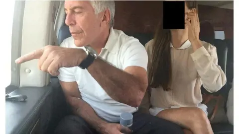 Jeffrey Epstein u bijeloj majici sjedi u zrakoplovu i pokazuje prstom kroz prozor.