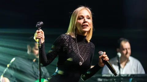 Jelena Rozga pjeva na pozornici u crnoj čipkastoj haljini s mikrofonom u ruci.