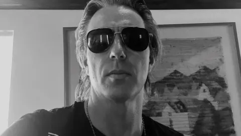 Crno-bijeli portret muškarca s tamnim sunčanim naočalama