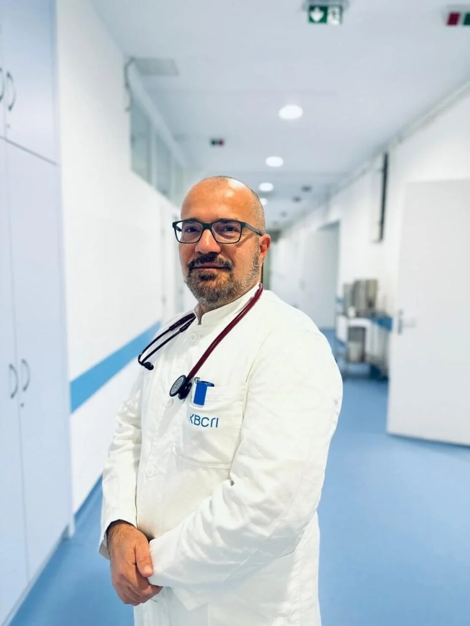 Liječnik u bijeloj kuti sa stetoskopom stoji u bolničkom hodniku