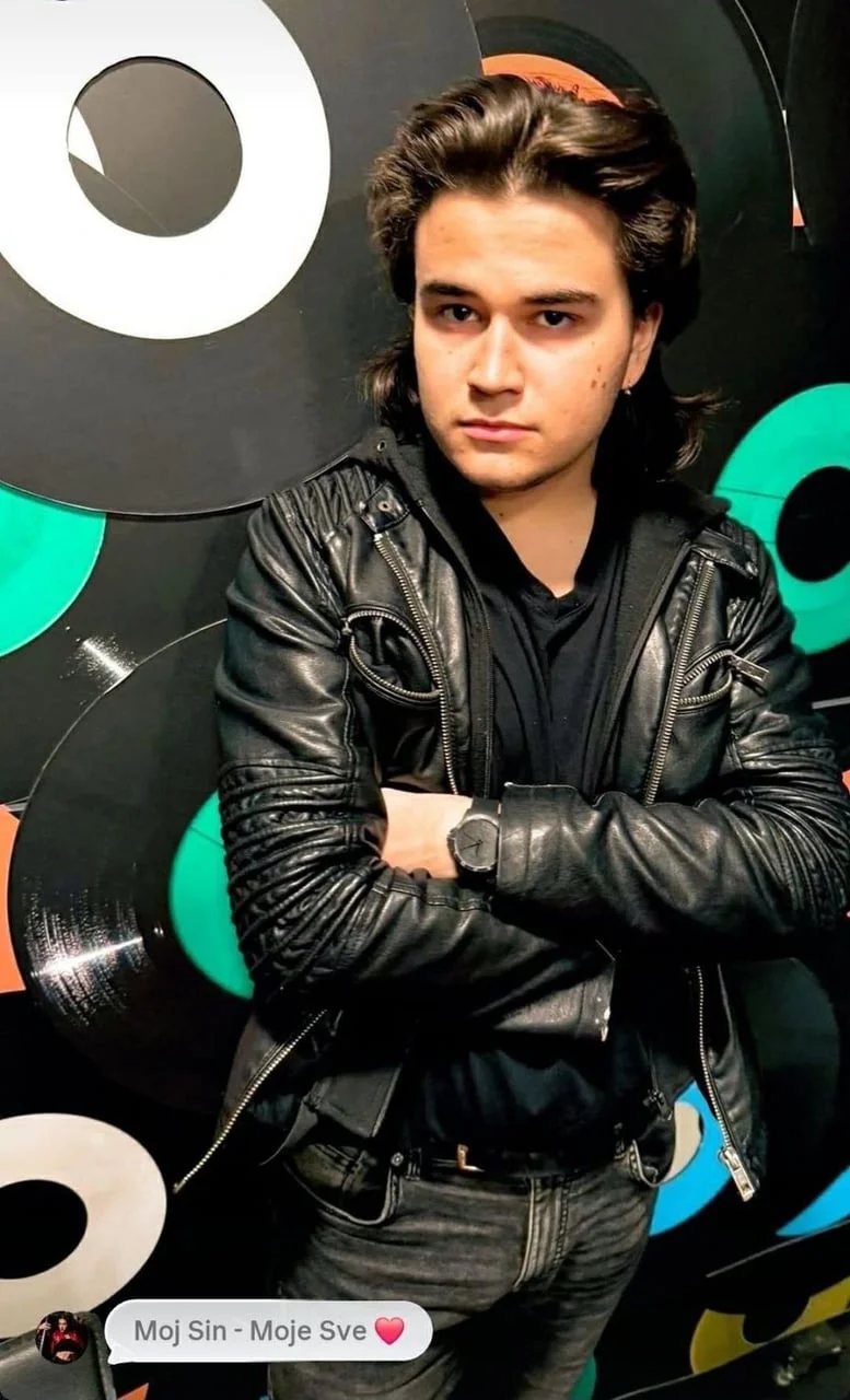 Darian Kalember u crnoj kožnoj jakni ispred zida s gramofonskim pločama