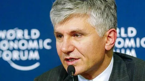 Zoran Đinđić govori za mikrofonom ispred znaka Svjetskog gospodarskog foruma.