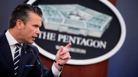 Pete Hegseth govori za govornicom ispred logotipa Pentagona.