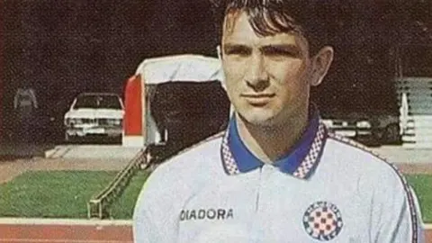 Mladi Zlatko Dalić u bijelom dresu Hajduka na atletskoj stazi stadiona.