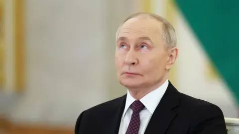 Portret Vladimira Putina u tamnom odijelu s kravatom