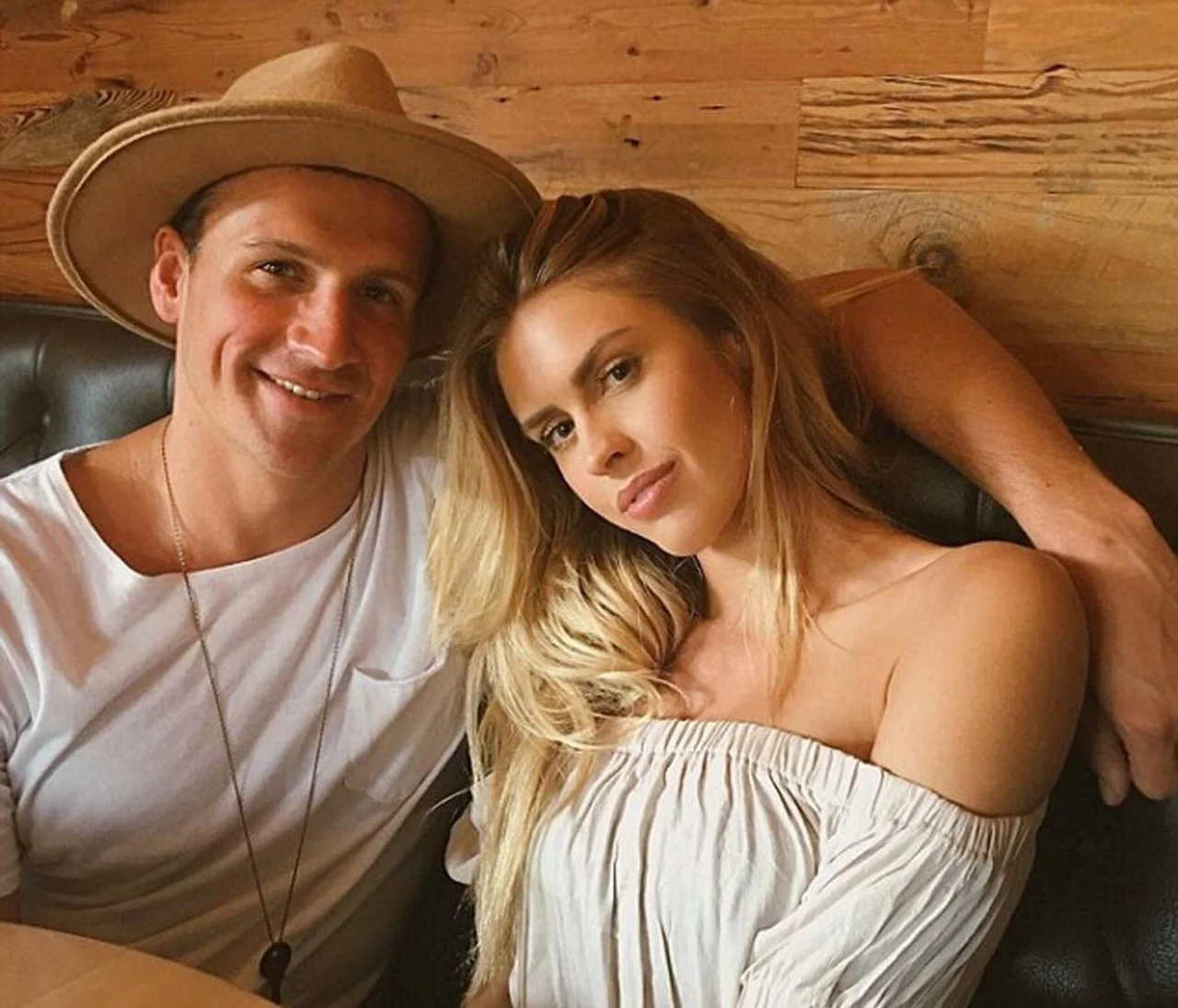 Ryan Lochte sa šeširom i Kayla Rae Reid poziraju zagrljeni u restoranu.